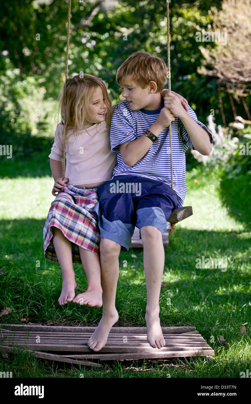 Boy and girl on tree swing Stock Photo Alamy
