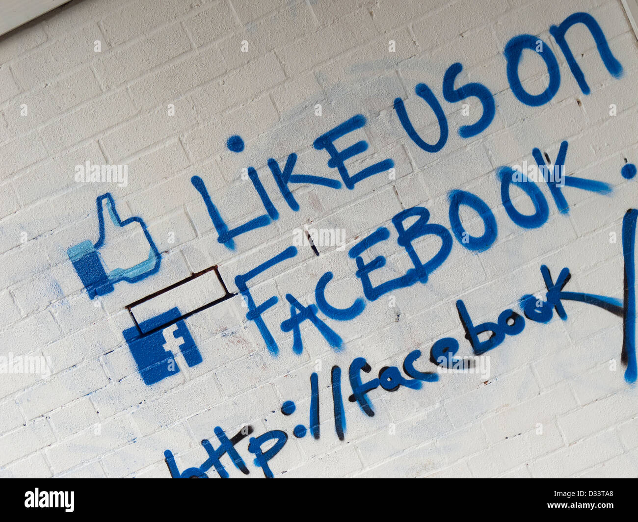 Like us on facebook call to action painted on a brick wall. Stock Photo