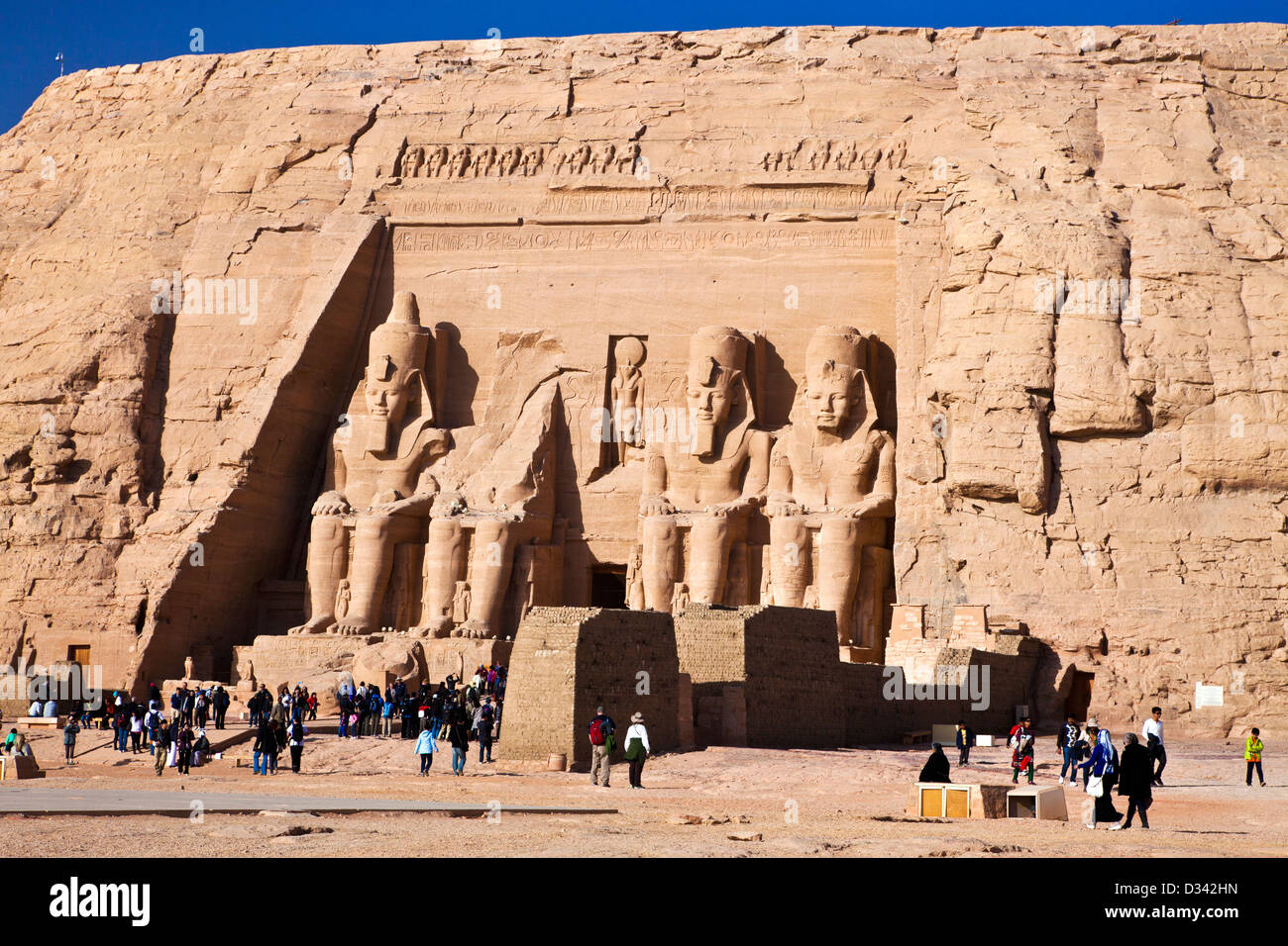 Tourists at the famous site of the Great Temple at Abu Simbel, Egypt are dwarfed by the huge statues of Ramesses II Stock Photo