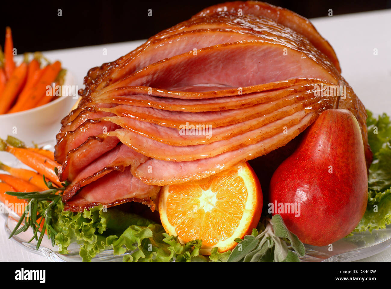 A spiral cut honey glazed Easter ham with fruit and carrots Stock Photo