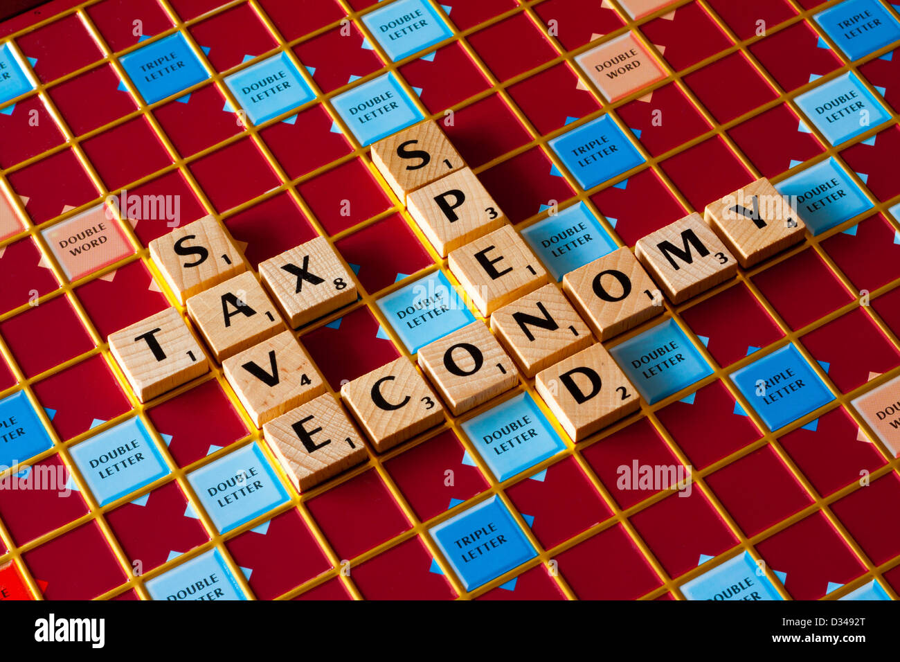 Scrabble board spelling Save Tax Spend Economy words relevant to the budget and state of the economy and finance Stock Photo