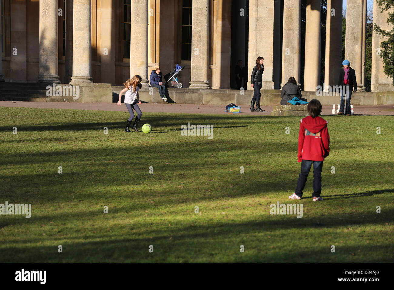 Boy And Girl (Cousins) Playing Football At the Pittville Pump Room Pleasure Gardens Cheltenham Gloucestershire England Stock Photo