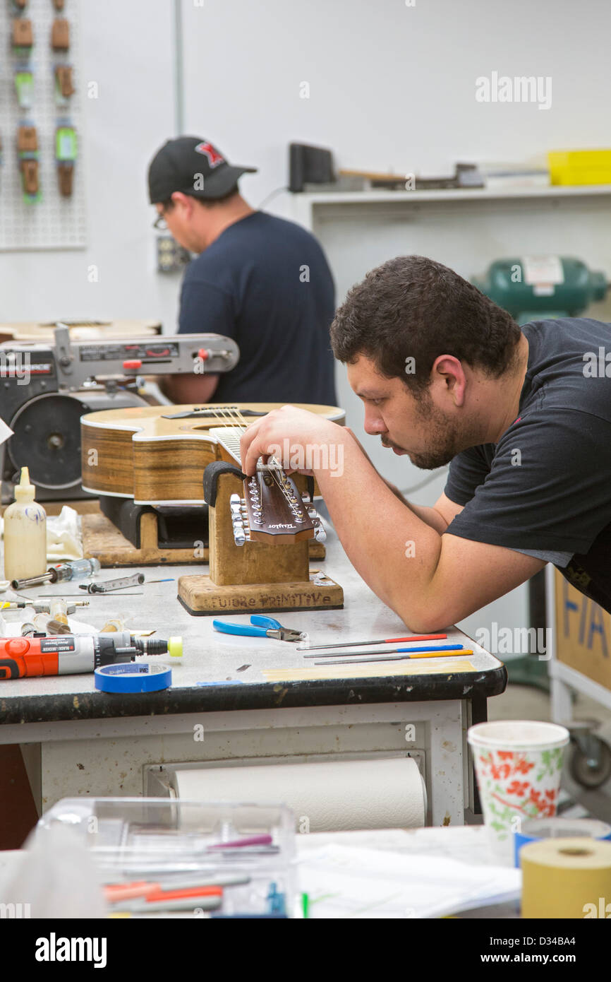 El Cajon, California Workers put strings on finished guitars at the