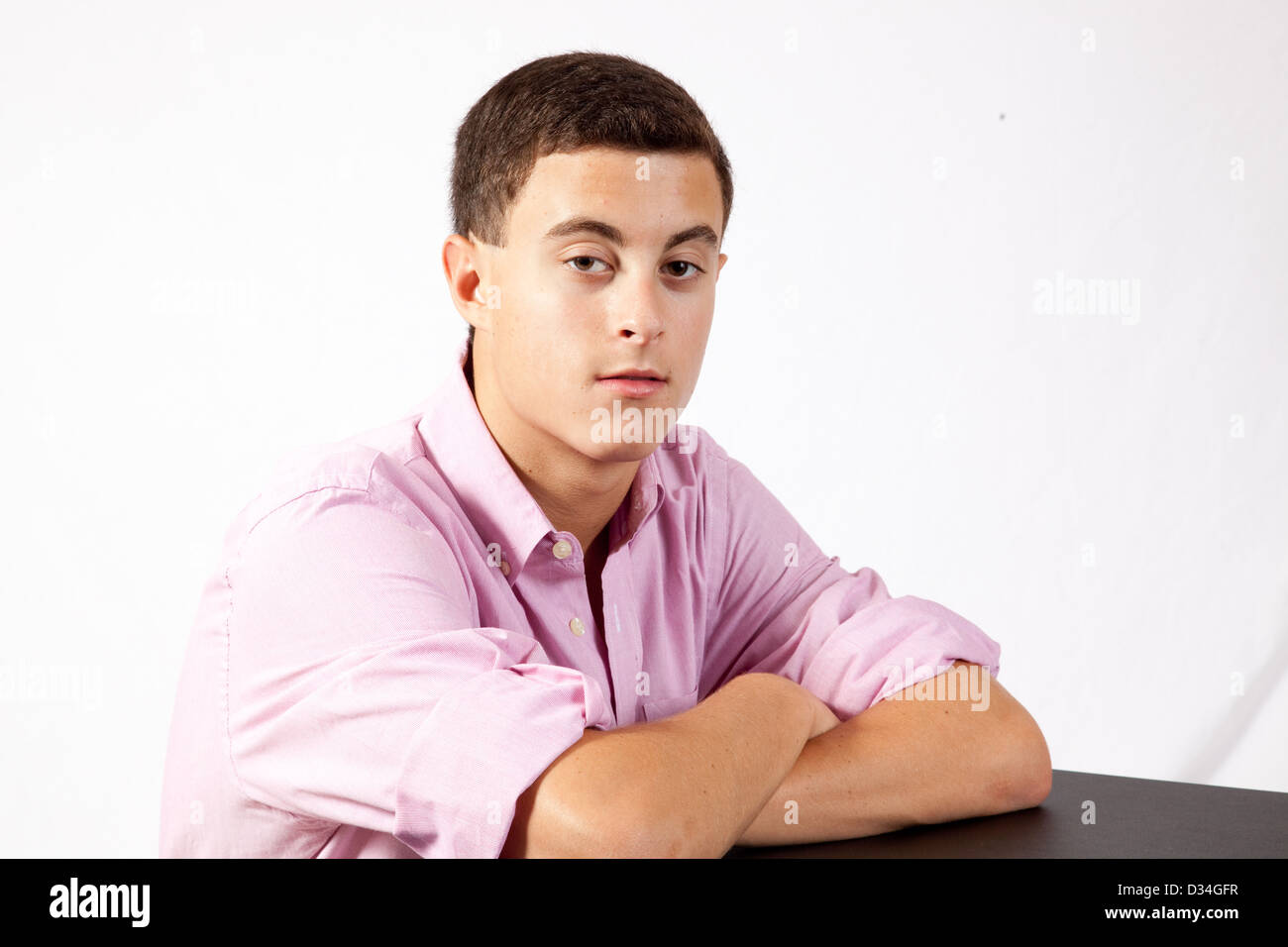 Teenage boy looking at the camera with a thoughtful, pensive look and direct eye contact Stock Photo