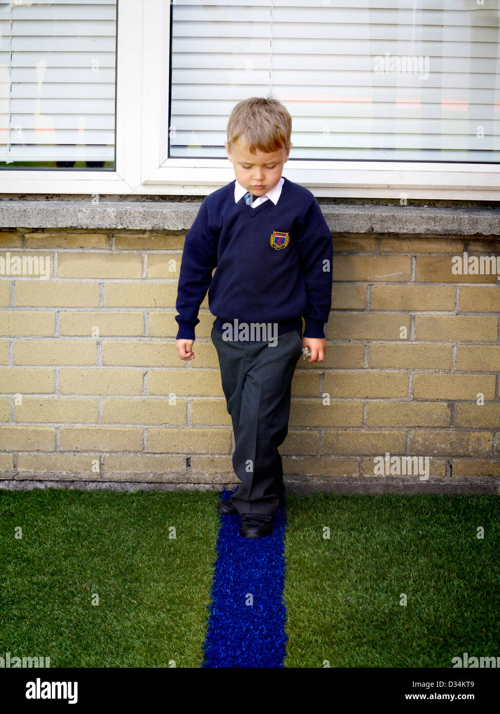 Small boy on blue line astroturf Stock Photo