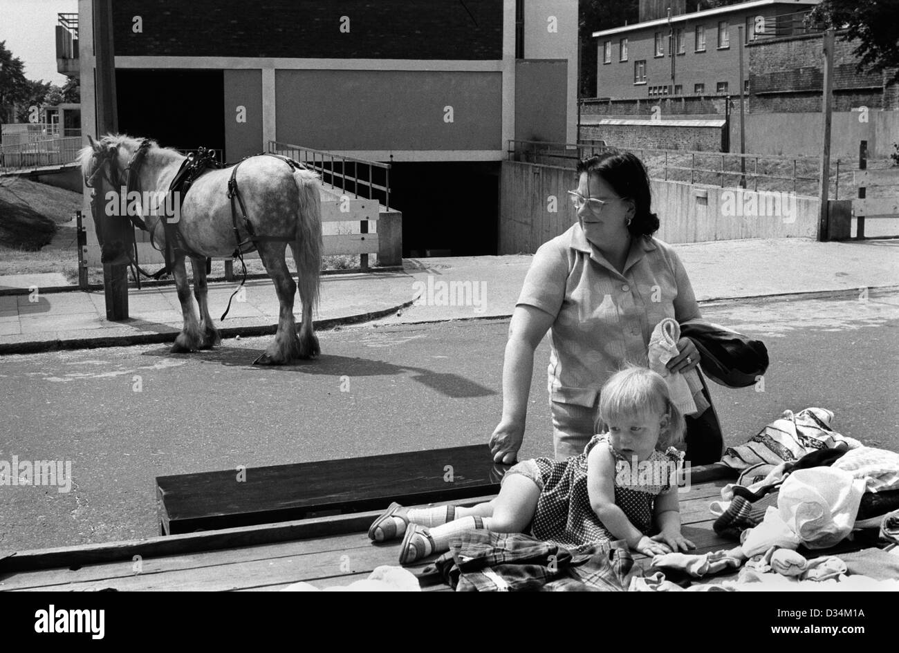 Portobello Road Saturday market 1970s London.  This is at the north end which was not prosperous. Families used to sell stuff to make ends meet. They are not selling antiques, essentially these are people who are in poverty but trying provide for their families 70s UK HOMER SYKES Stock Photo
