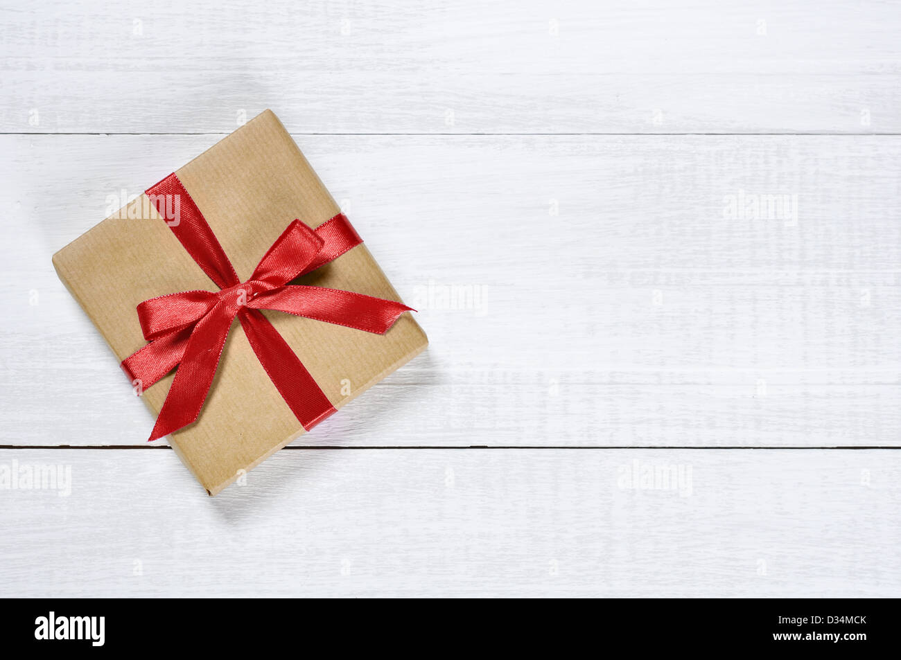 Gift box with red ribbon over white wooden background Stock Photo - Alamy