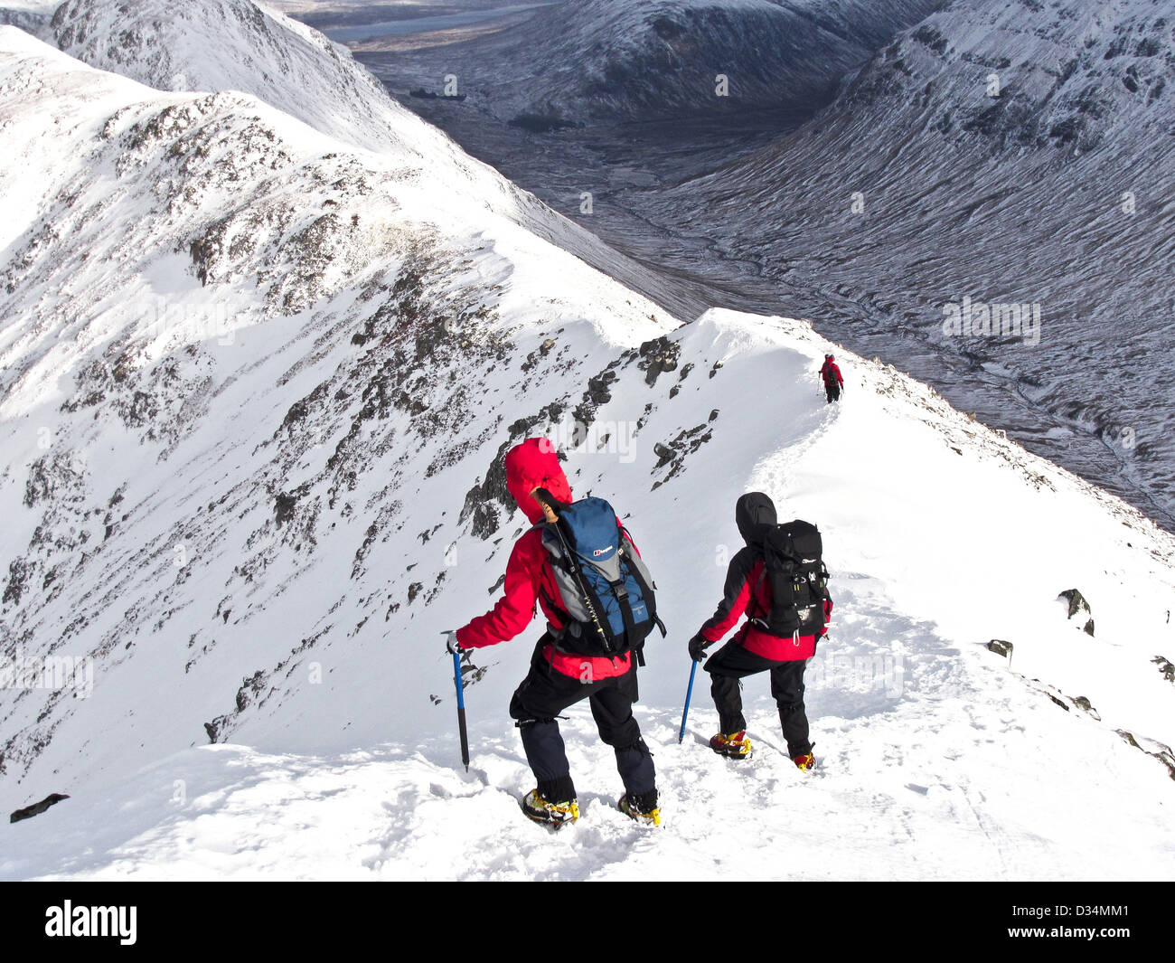 Two winter mountaineers descending a ridge on the Scottish mountain Buachaille Etive Beag  in Glencoe  in s, Scotland UK Stock Photo