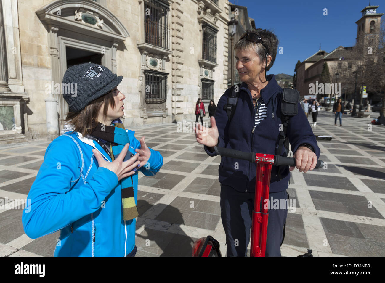 Middle aged woman on a Sagway being given instructions by young tour guide in Plaza Nueva Granada Spain Stock Photo
