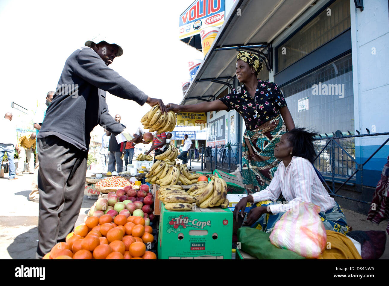 A man buying bananas in Lusaka City Market from a vendor Stock Photo