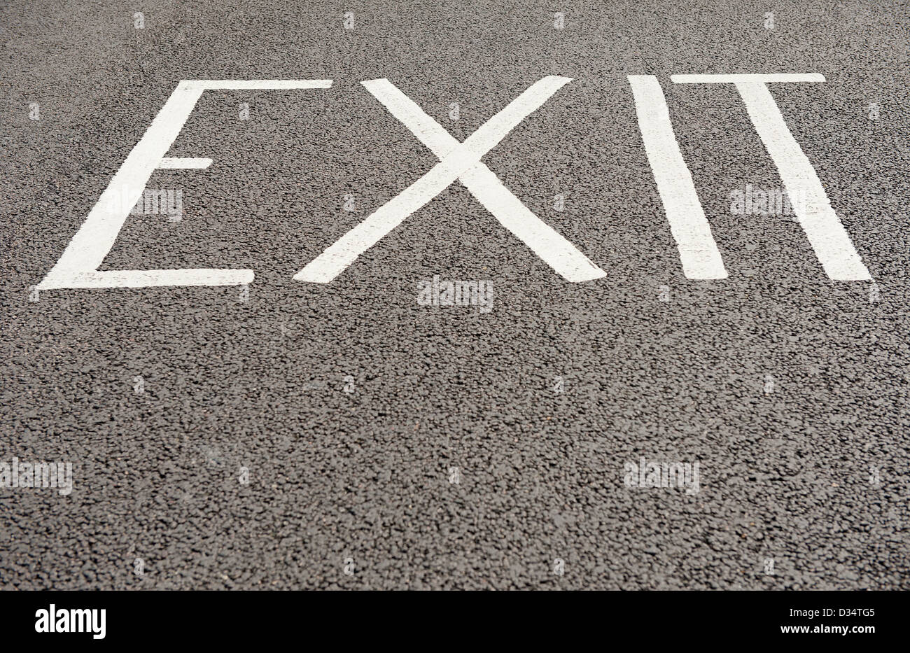 The word 'EXIT'  on a black tarmac road surface. Stock Photo