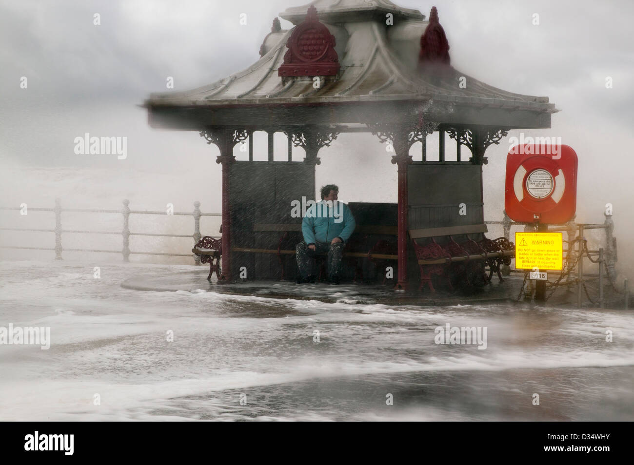 Storm on the old  Blackpool south central shore sea front.  Male sheltering in a pagoda type shelter Stock Photo