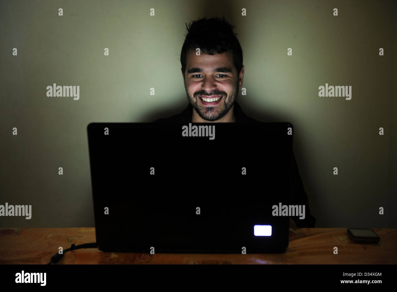 Happy young man on laptop computer smiling Stock Photo