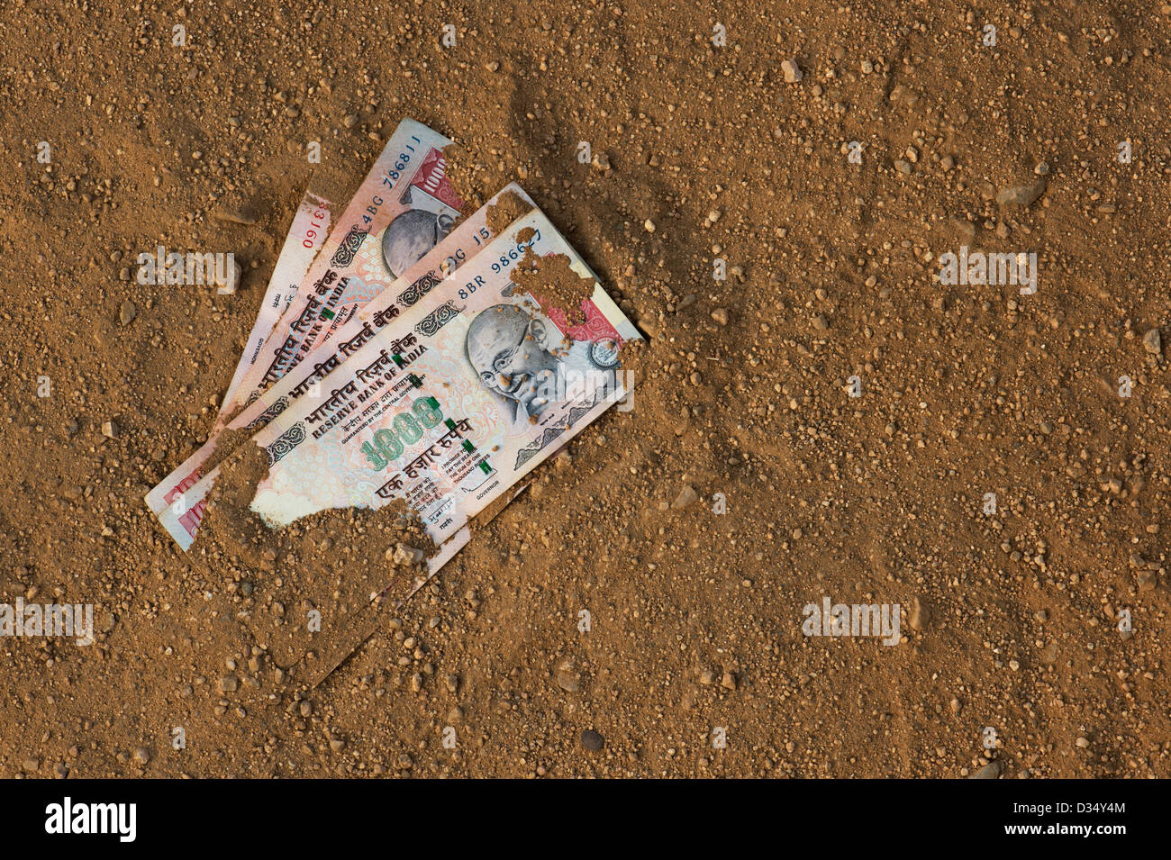 Indian thousand rupee notes on a dirt track. India Stock Photo