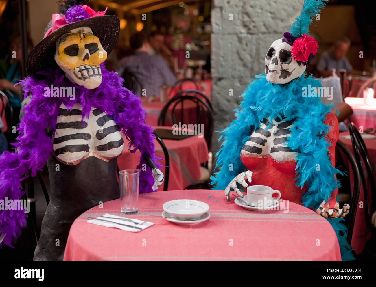 Dressed-up papier mache skeletons sitting at cafe table on Zocalo during Day of the Dead, Oaxaca, Mexico. Stock Photo