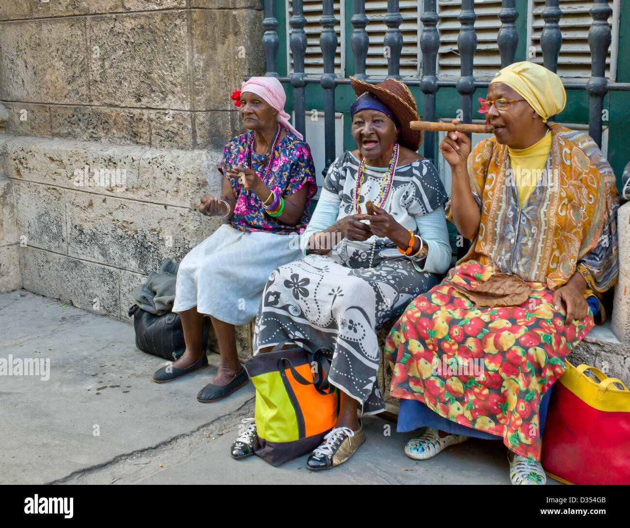 Three old ladies sit on the wall smoking home rolled Havana cigars for
