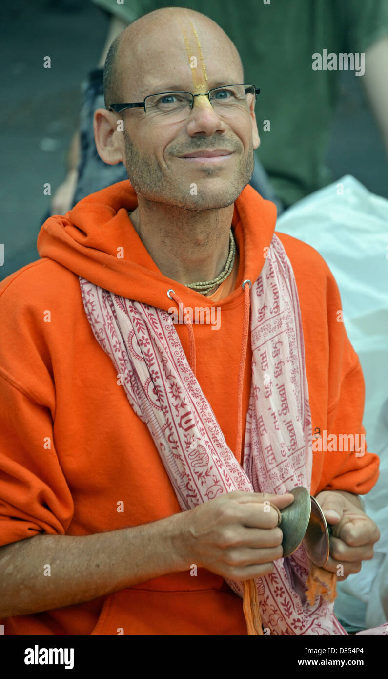 MIddle aged bald Hare Krishna street performer playing cymbals in Union Square Park, New York City Stock Photo