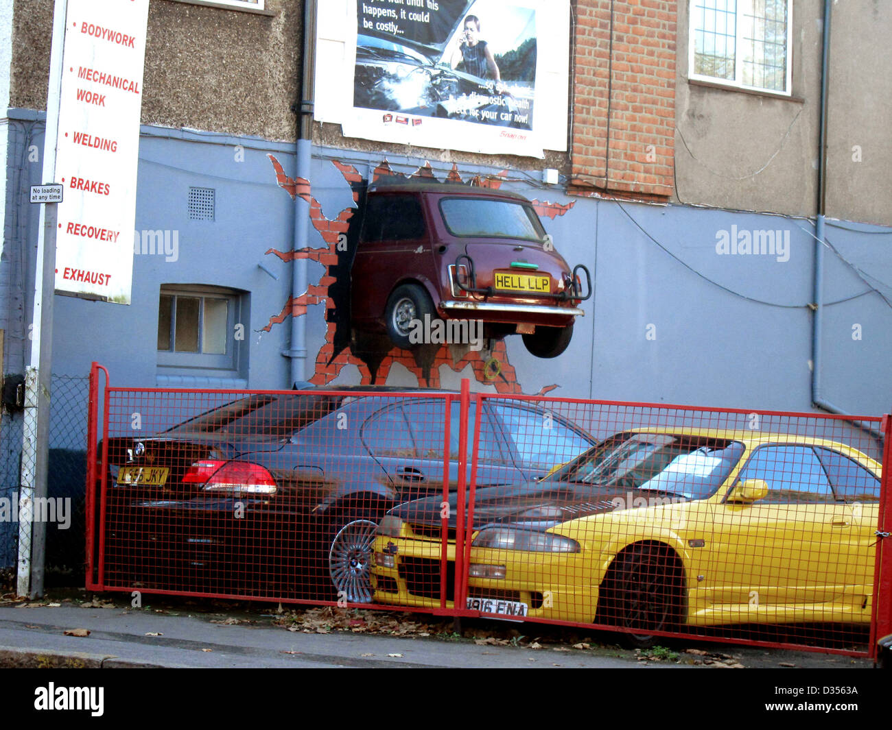 Classic mini car half through a wall as a used car lot advertising