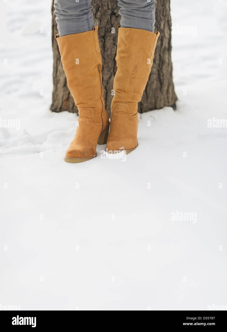 Closeup on female legs in winter boots on snow Stock Photo