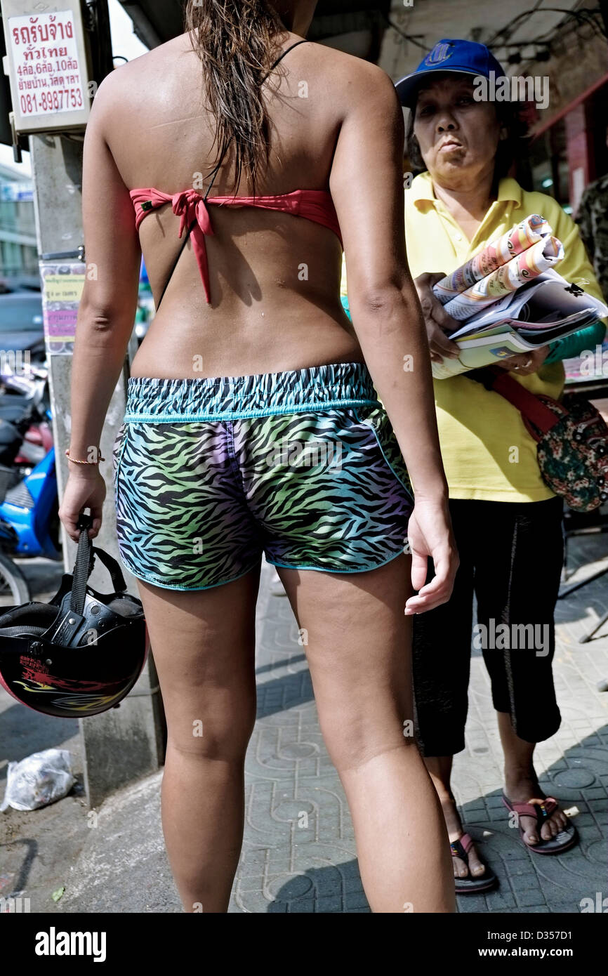 Inappropriate clothing. Scantily dressed young Caucasian woman tourist  receives a disapproving look from an elderly Thai female. Thailand S. E.  Asia Stock Photo - Alamy