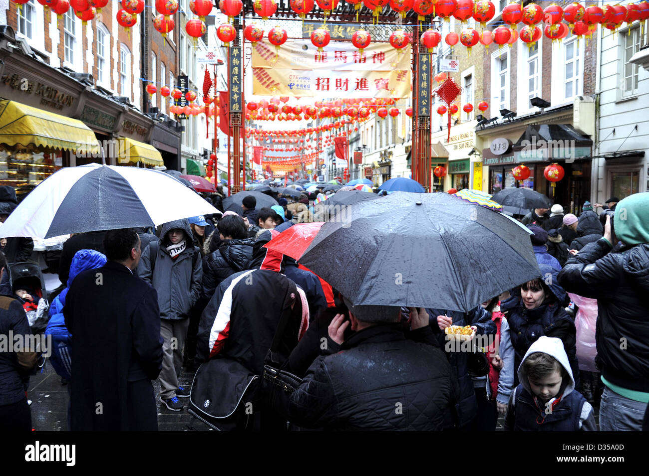 London 10th February 2013.  A sea of umbrellas shield crowds of people from the rain in Gerrard Street Chinatown as they celebrate the Chinese New Year. This is the year of the snake.  Thousands of people lined the streets to se the colourful parade and sample Chinese food despite the cold wet weather. Stock Photo
