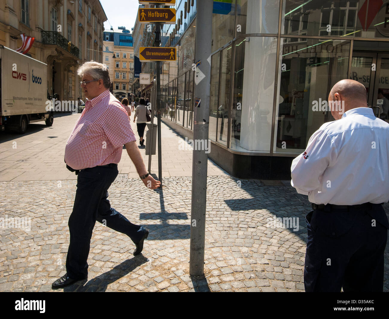 A man in midlle age walking sunny street Stock Photo
