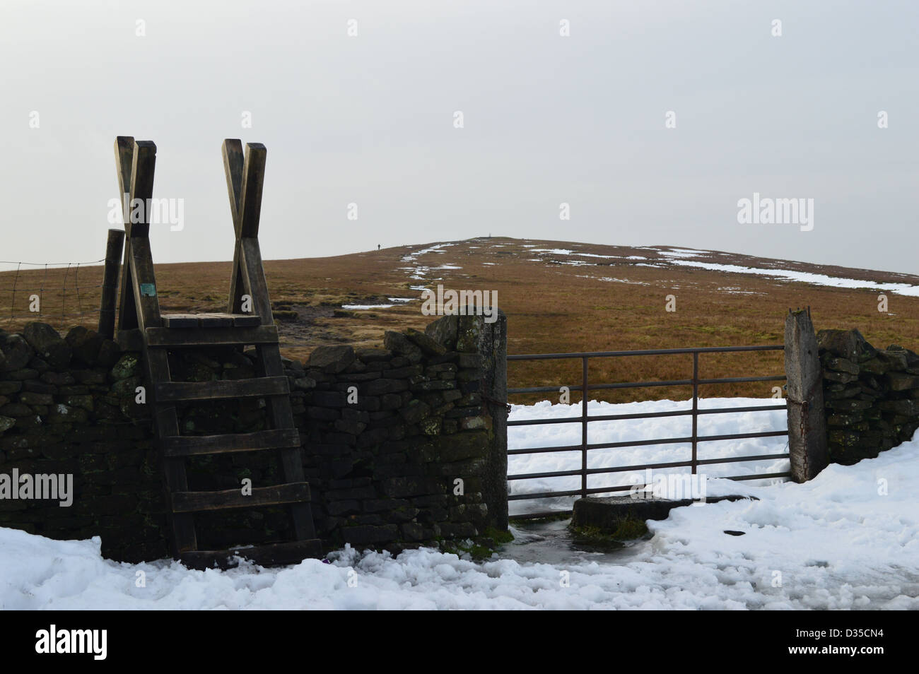 Hill Walker Nearing the Summit Trig Point of Pendle Hill in Winter Stock Photo