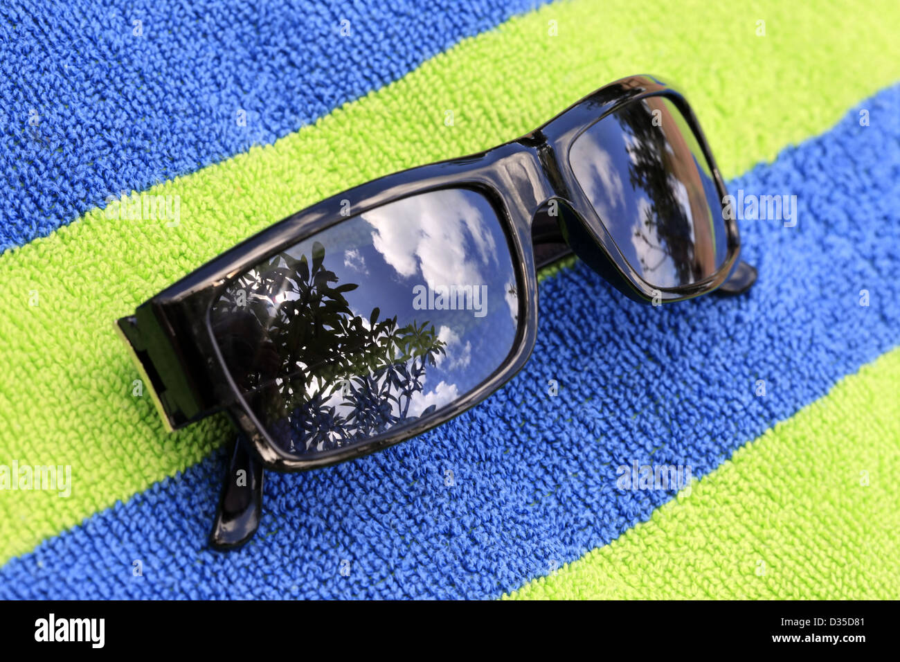Solar glasses with reflection on a bluegreen towel Stock Photo Alamy