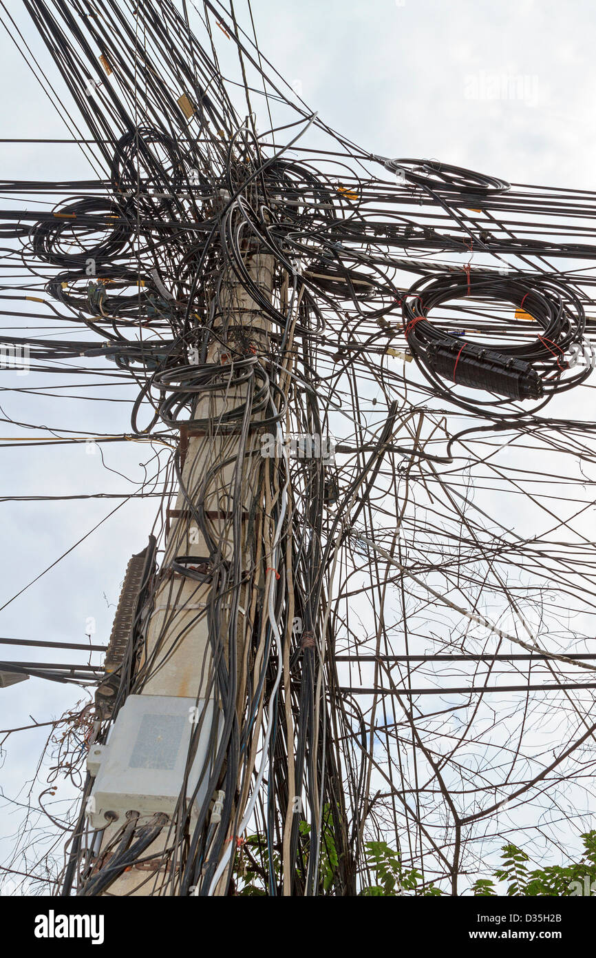 Rat's nest of electrical wiring typical of third world Asian countries. This is along one of Phnom Penh's streets. Cambodia. Stock Photo