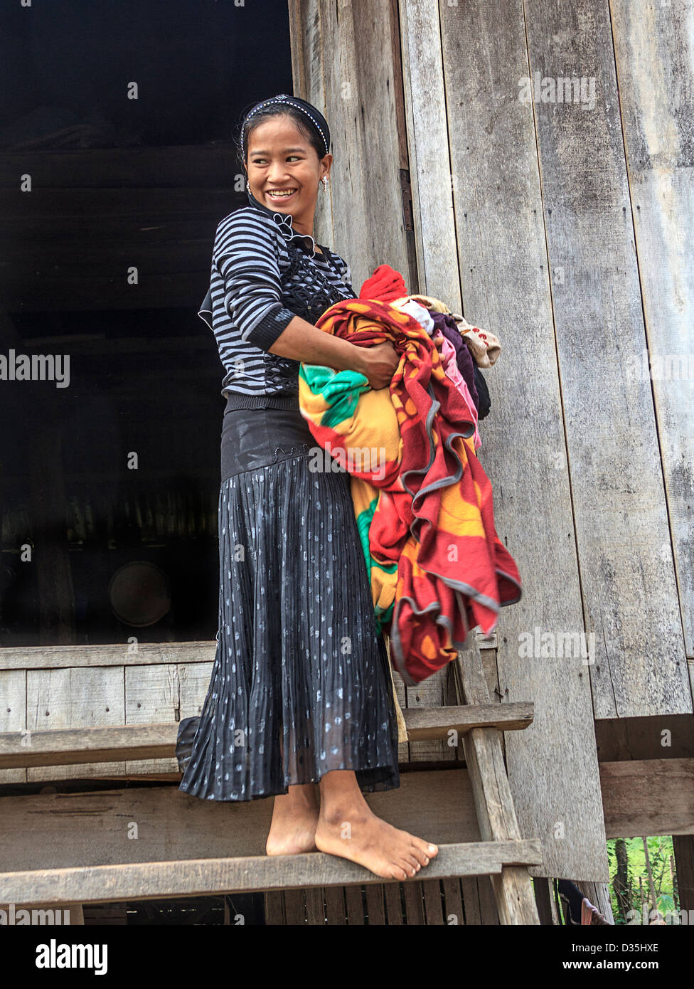 Young woman carries laundry, one of Cham people living in a village along the Mekong River south of Kratie, Cambodia. Stock Photo