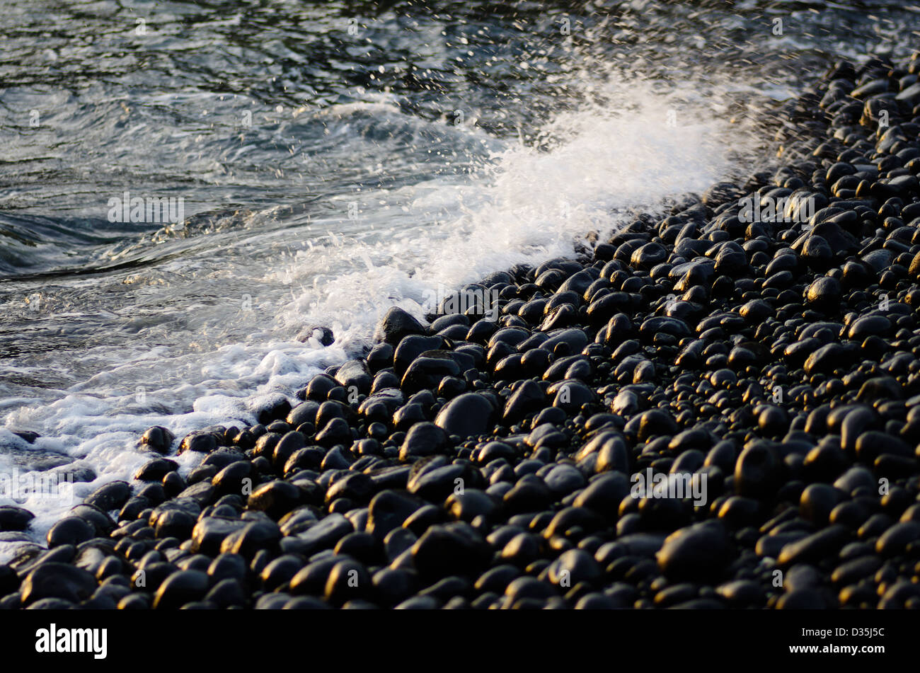 Sunset reflecting on the black pebbles on Omotohama snorkeling beach, Hahajima, Ogasawara Islands, Tokyo, Japan Stock Photo