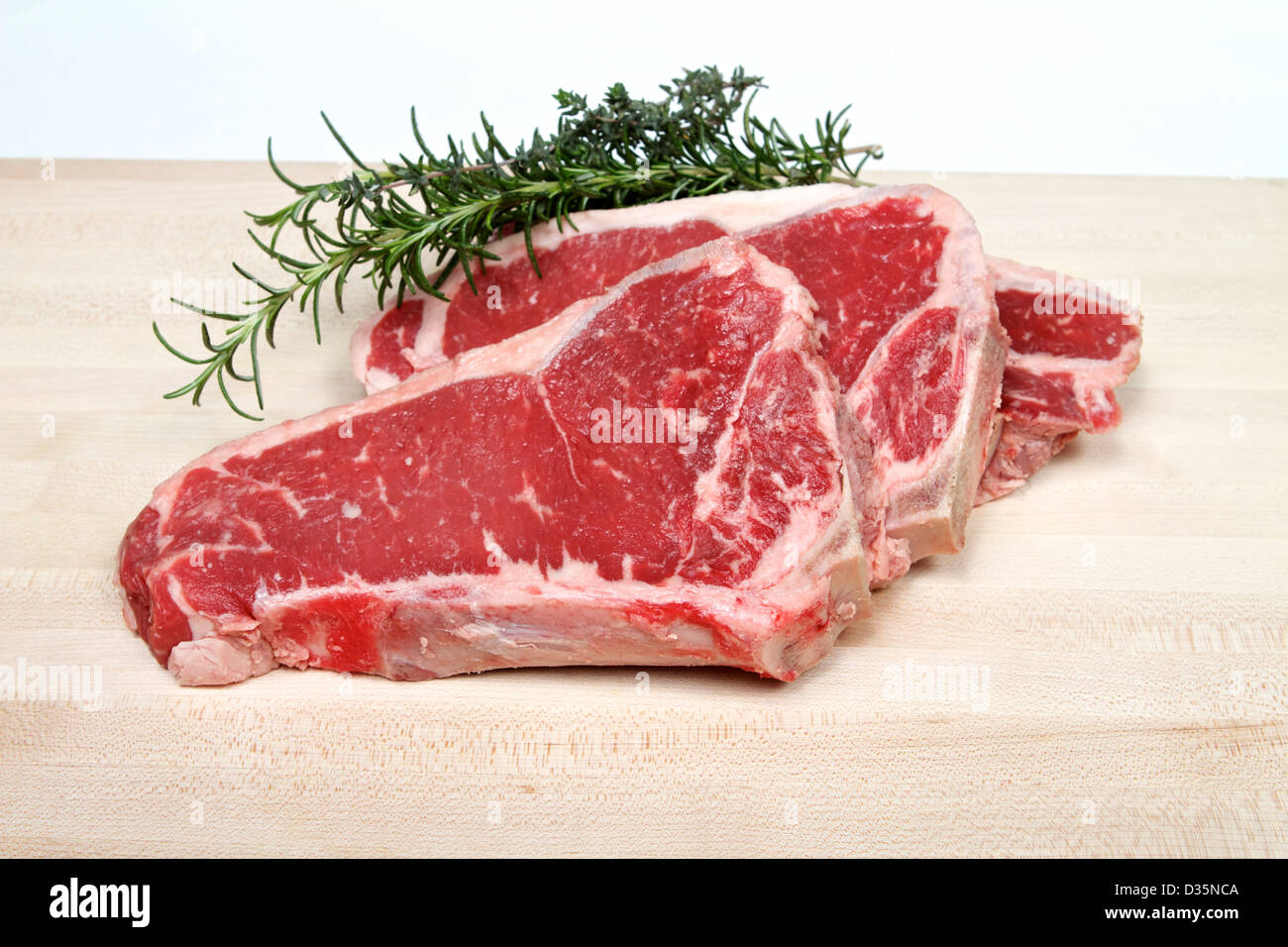 Fresh American (new york strip steak bone in) Sirloin steak on a cutting board with rosemary and