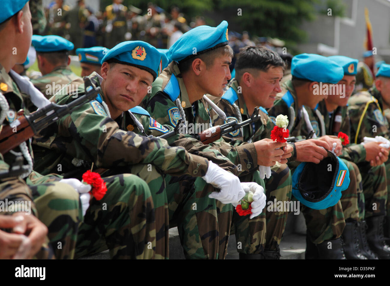 Tajik soldiers with carnations at a Soviet Veteran's day celebration in