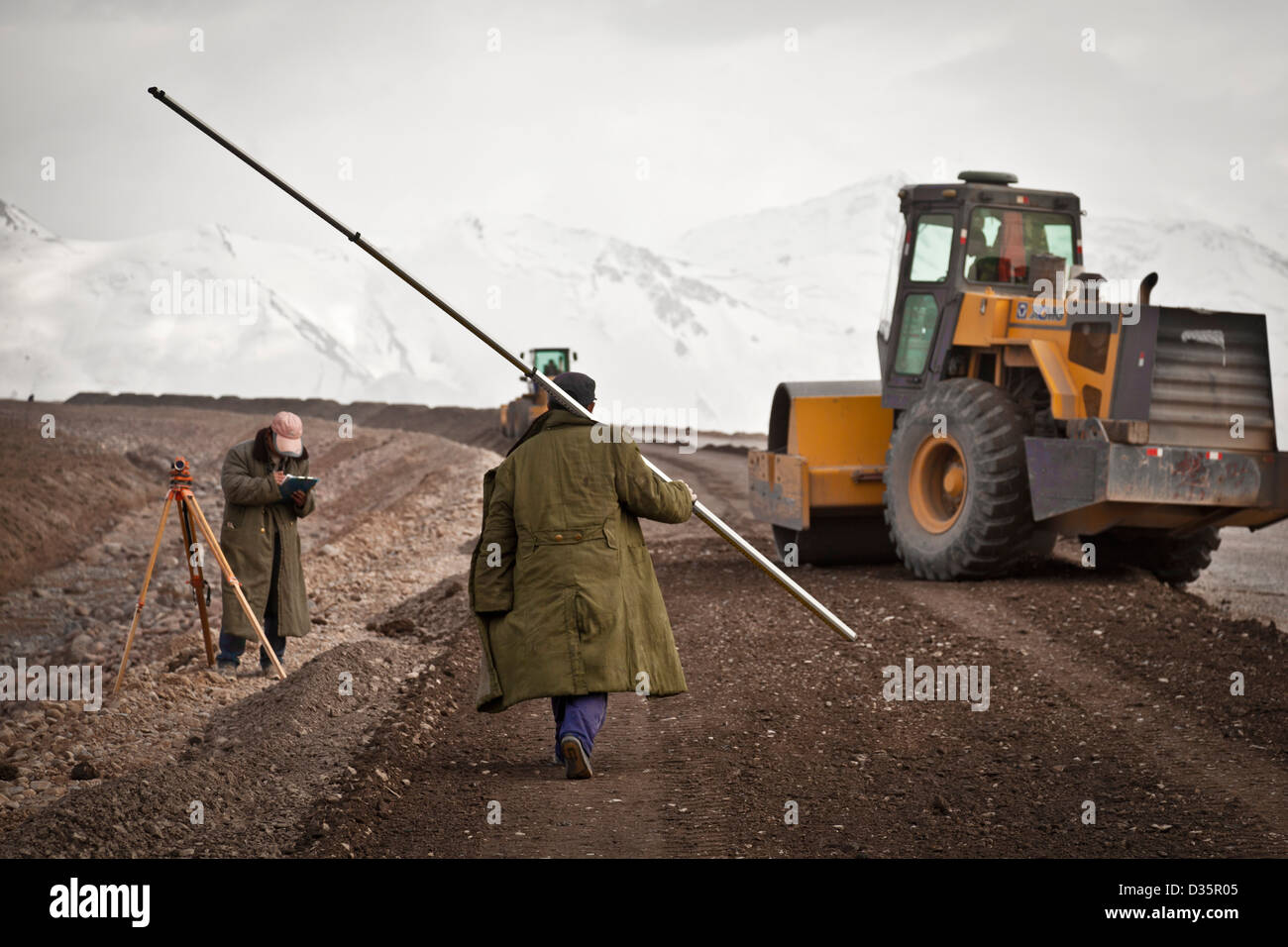 Chinese road construction workers paving a road from Sary Tash, Kyrgyzstan to the Irkeshtam border crossing with China Stock Photo