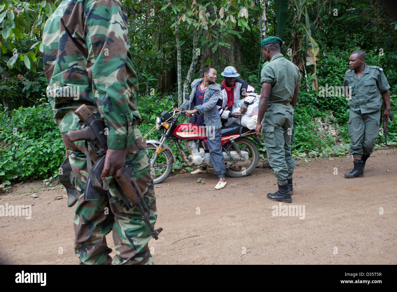 CONGO, 29th Sept 2012: Ecoguards patrol an area of forest down a logging trail.  No animal hunting is allowed in this area. They check a passing motobike for bushmeat or ivory.  Photograph by Mike Goldwater Stock Photo