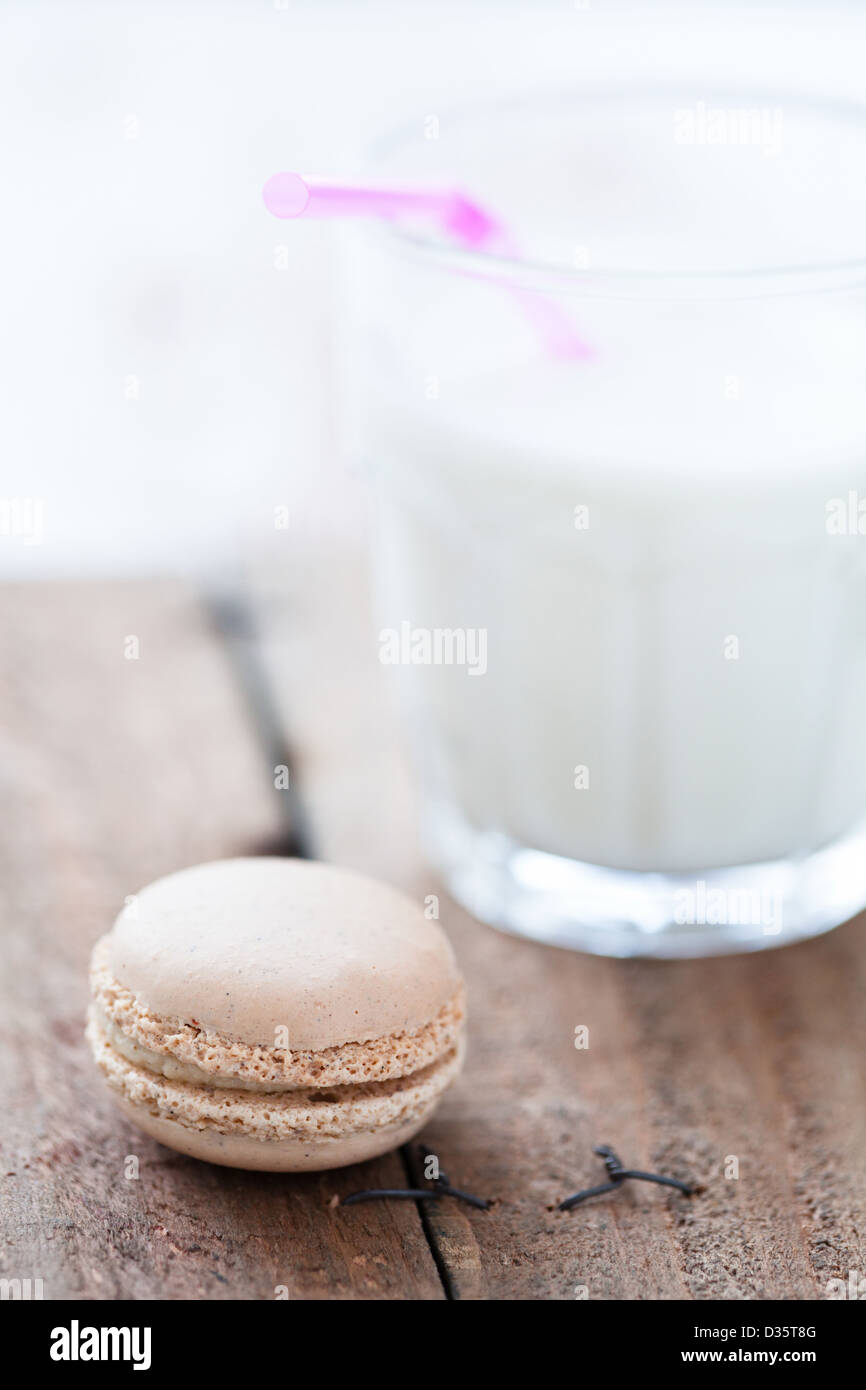 Closeup of macaroon and glass of milk on wooden table Stock Photo