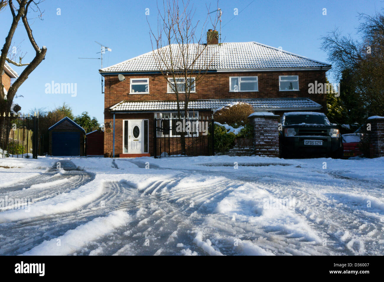 Wheel ruts in snow on an icy residential road. Stock Photo