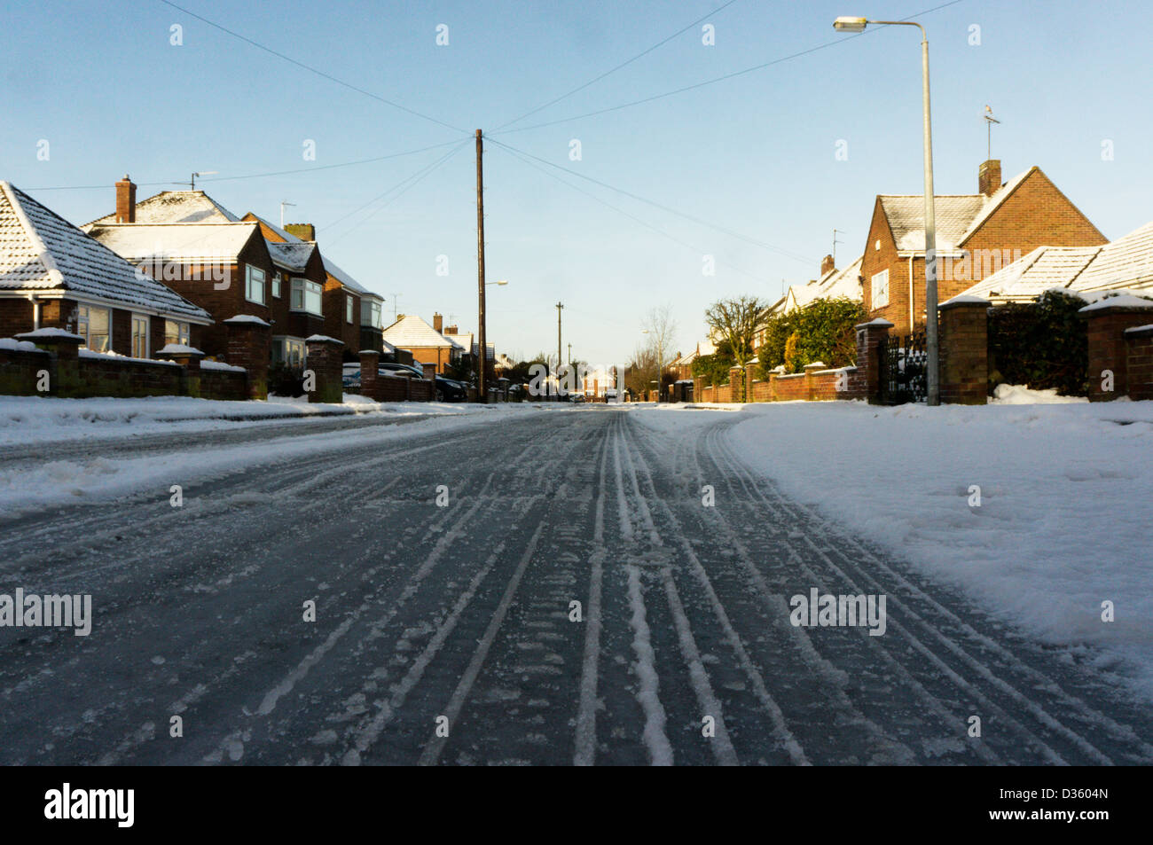 Wheel ruts in snow on an icy residential road. Stock Photo