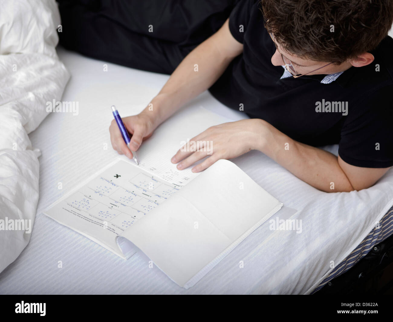 Young male student studying at home Stock Photo - Alamy
