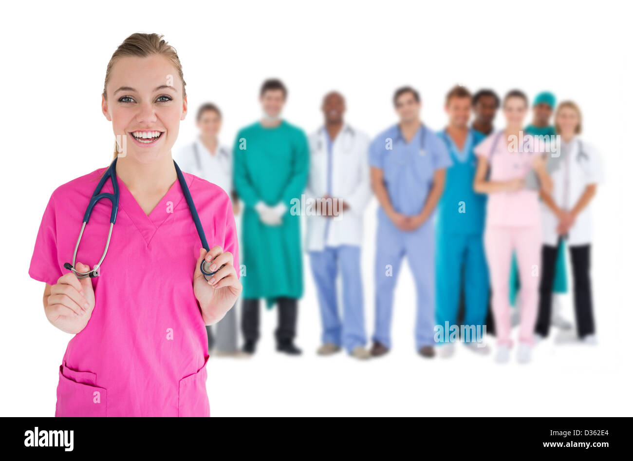 Smiling nurse with medical staff behind her Stock Photo