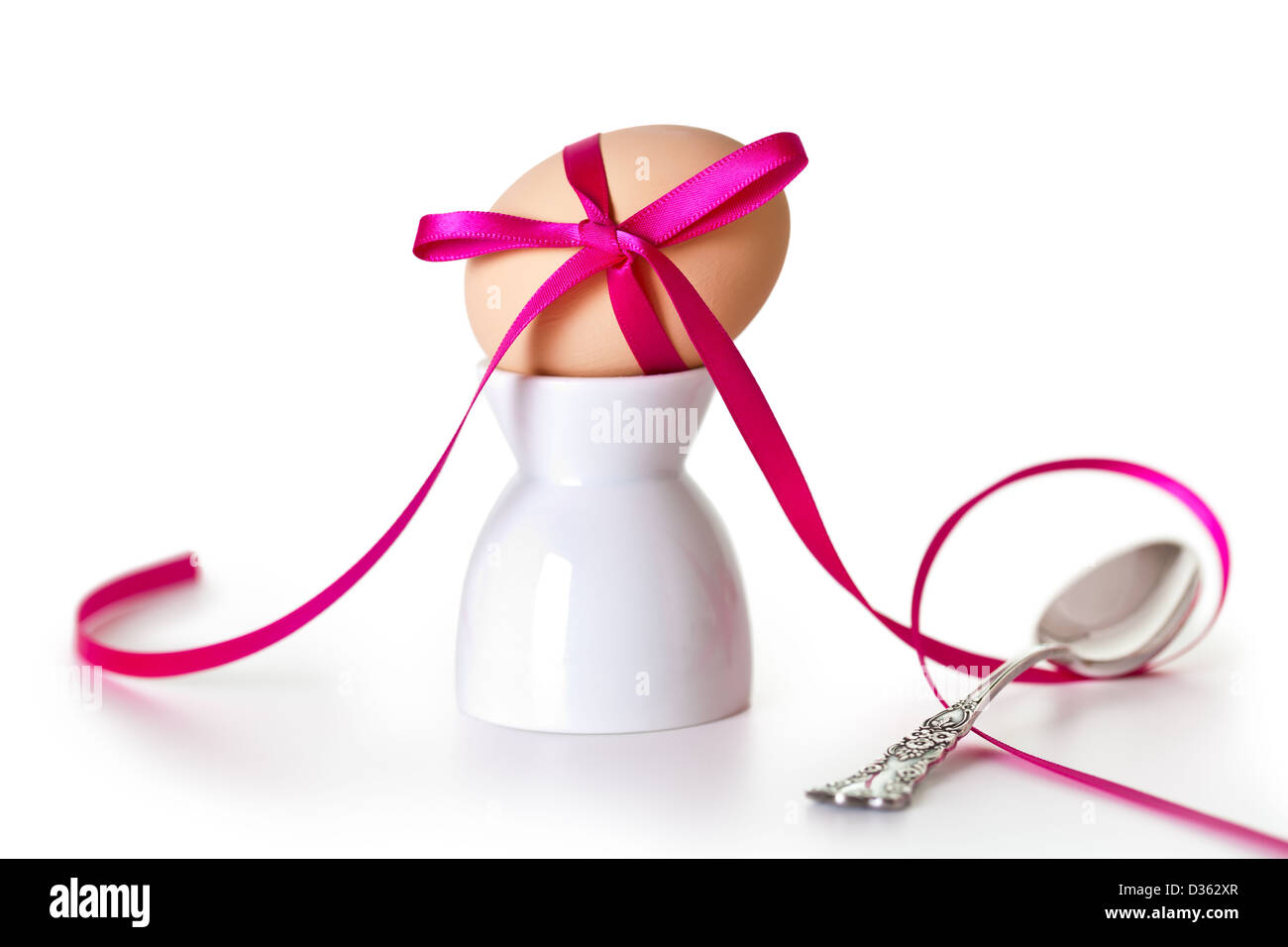 Easter egg with pink ribbon on white background. Composition with ...
