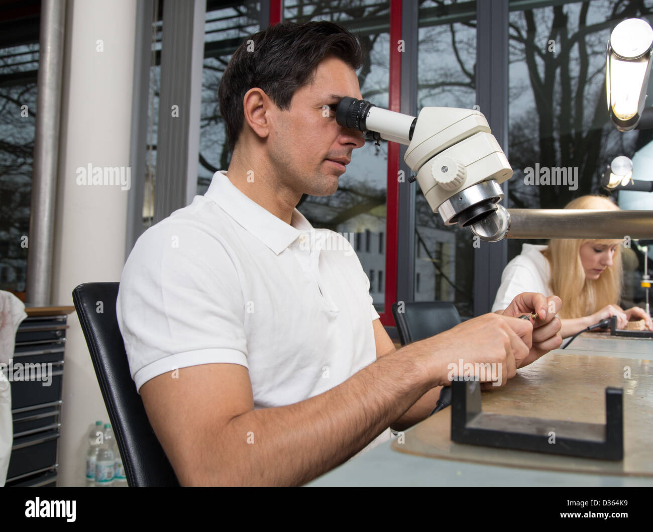 Two dental technicians at their workplace polishing dental prosthesis