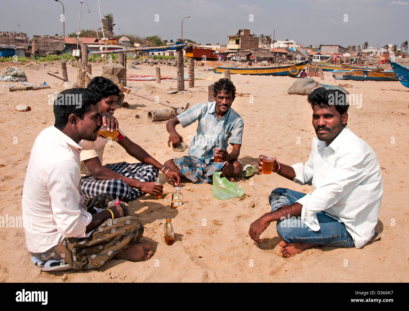 Fisherman drinking whiskey spirits Fishing Port Village Chennai ( Madras ) India Tamil Nadu Stock Photo