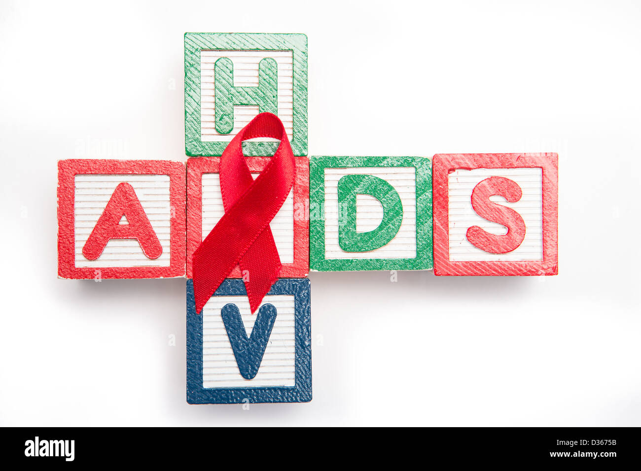 Wood blocks spelling aids and hiv in a cross shape with red awareness ribbon Stock Photo
