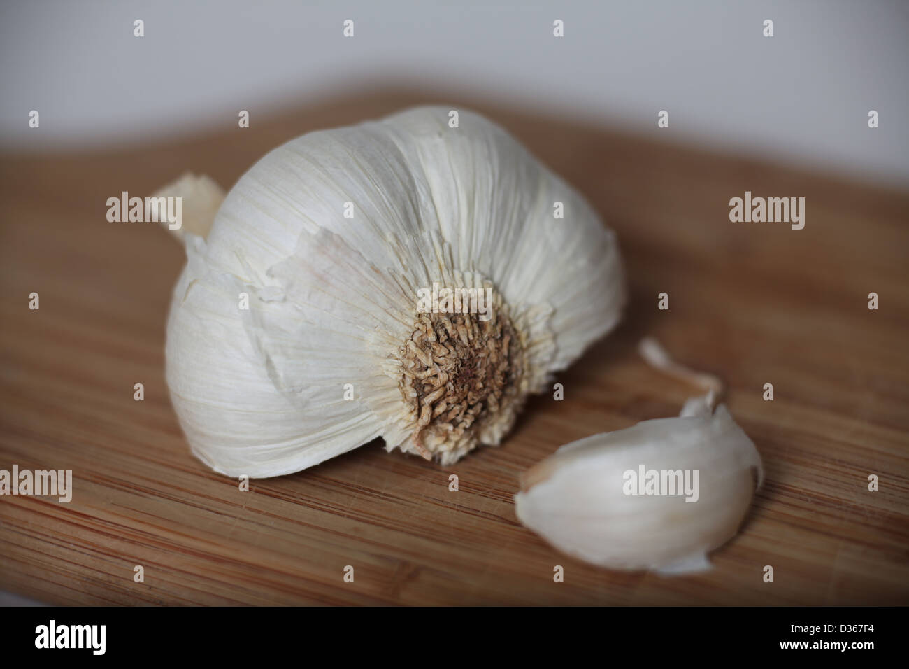 Half a bulb of Garlic on a wooden chopping board Stock Photo - Alamy