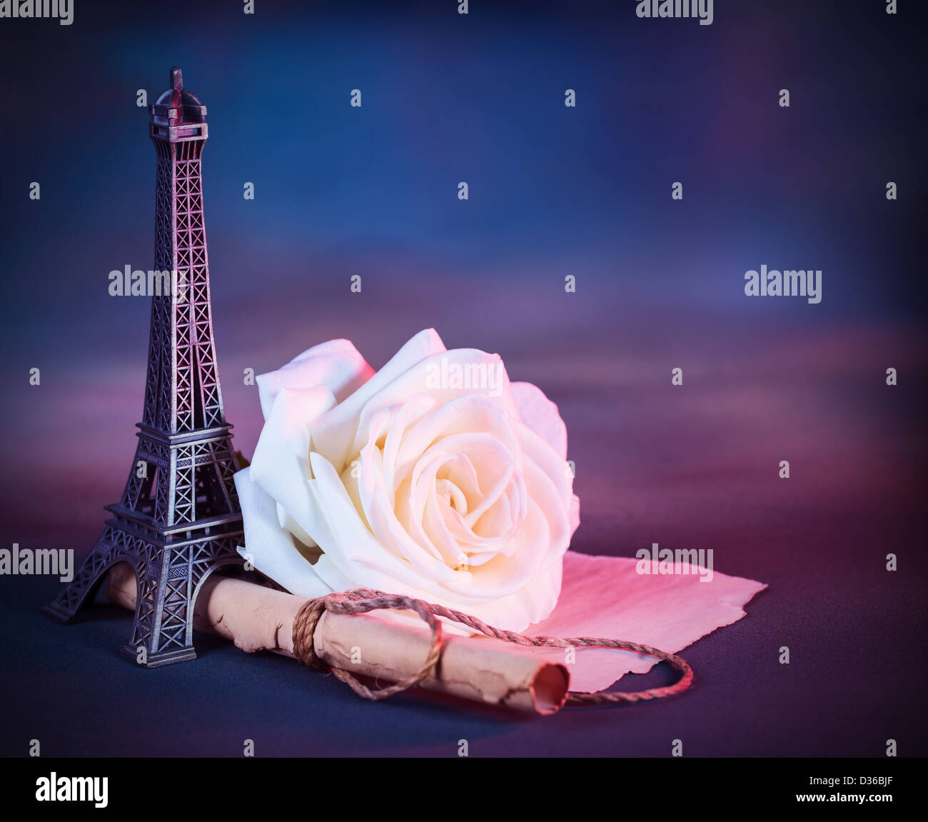 Image of festive greeting card with fresh white rose on the table decorated with small Eiffel tower, vintage photo Stock Photo