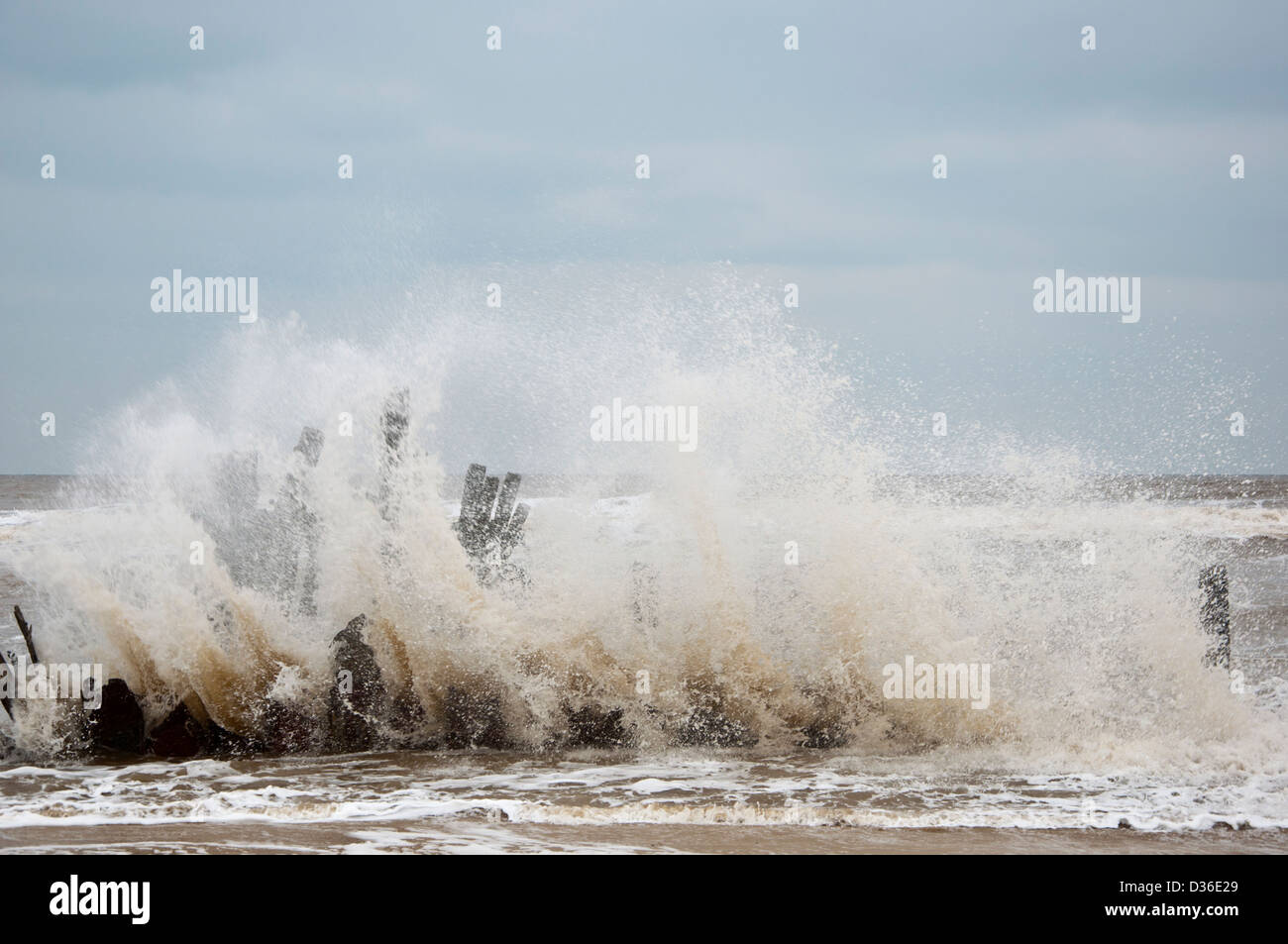 Old Sea defences with Waves breaking  Happisburgh Beach coastal erosion Stock Photo