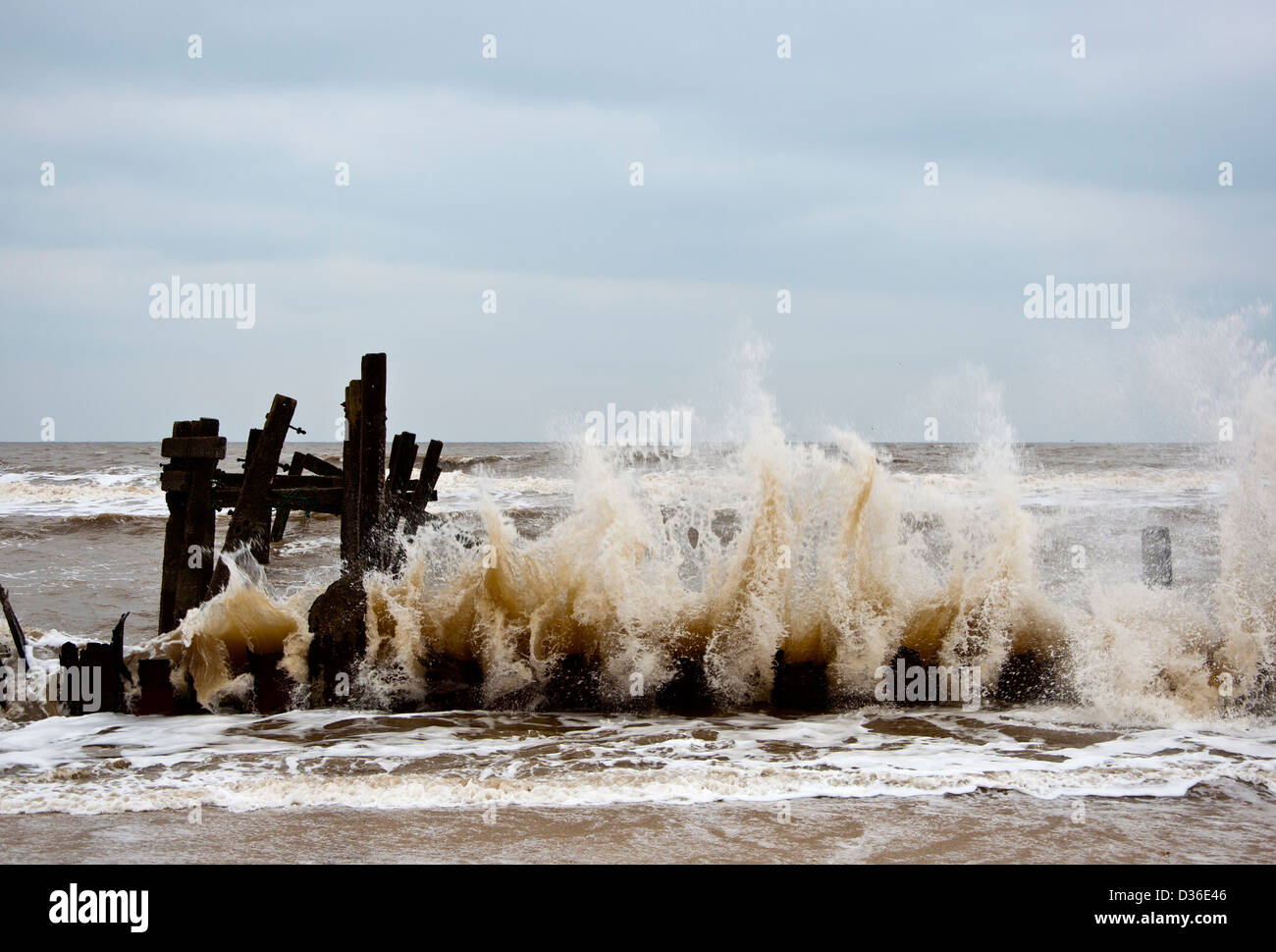 Old Sea defences with Waves breaking Happisburgh Beach coastal erosion ...