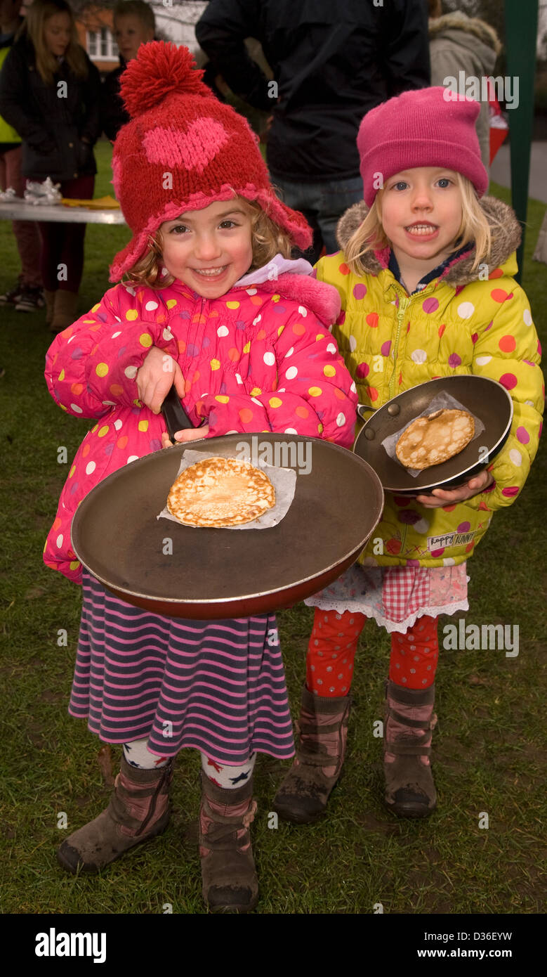 Two four year old sisters showing off their pancakes for pancake day, Farnham, Surrey, UK. Stock Photo