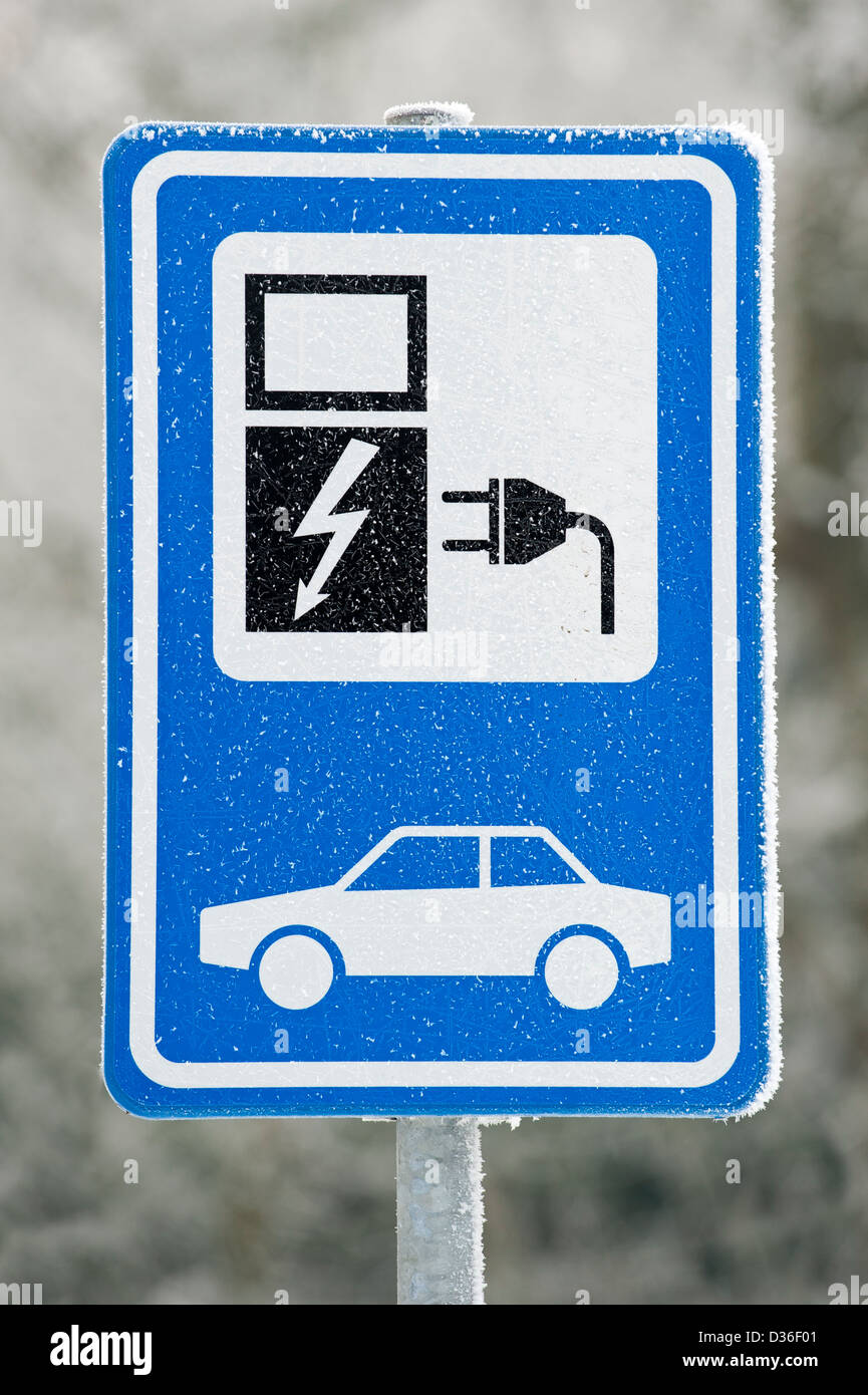 Electric vehicle charging station sign at car park in the snow in winter, Belgium Stock Photo